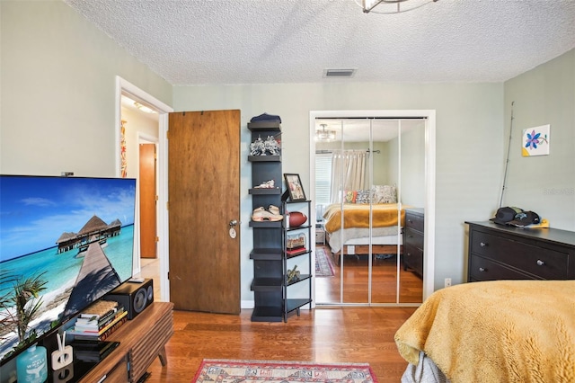 bedroom featuring a textured ceiling, hardwood / wood-style flooring, and a closet