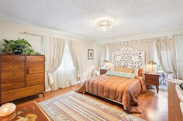 bedroom featuring hardwood / wood-style floors and a textured ceiling