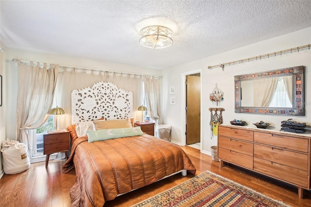 bedroom featuring a textured ceiling and dark hardwood / wood-style flooring