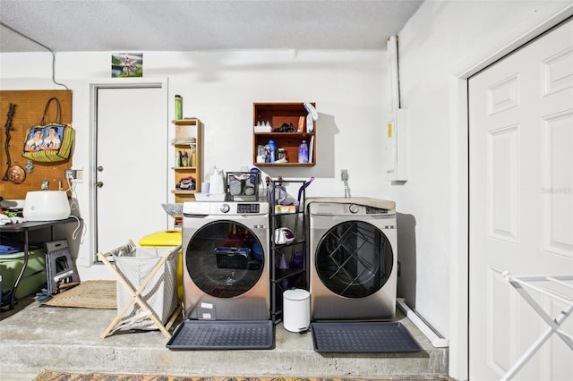 laundry area with a textured ceiling and separate washer and dryer