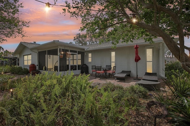 back house at dusk with a patio