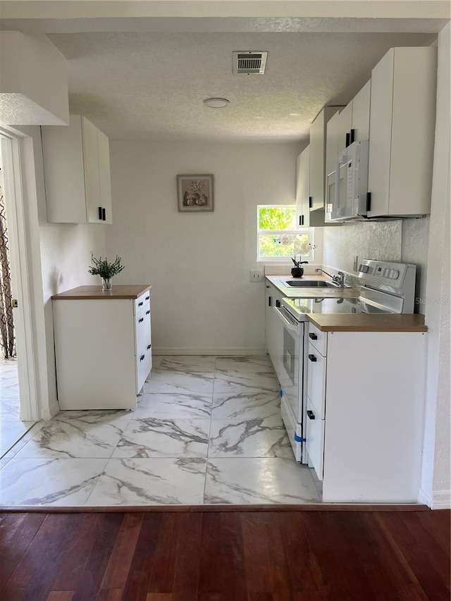 kitchen featuring sink, white cabinetry, white appliances, and light hardwood / wood-style floors