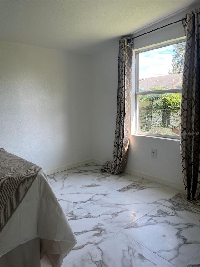 bedroom featuring a textured ceiling and multiple windows