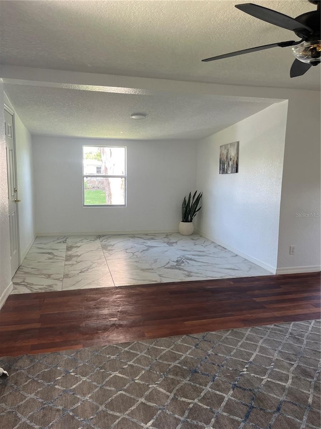 spare room with a textured ceiling, hardwood / wood-style flooring, and ceiling fan