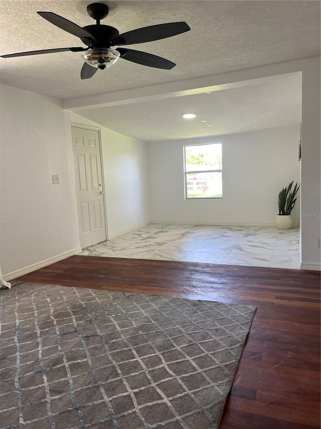 spare room with a textured ceiling, dark hardwood / wood-style floors, and ceiling fan