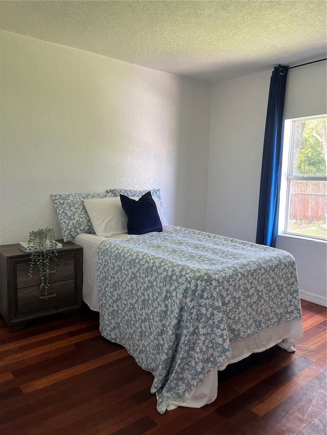 bedroom with dark wood-type flooring and a textured ceiling