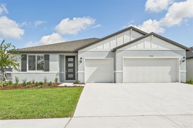 view of front of property featuring a front lawn and a garage