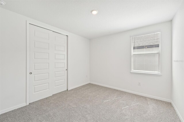 unfurnished bedroom featuring carpet and a closet