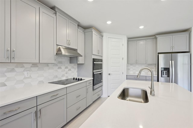 kitchen with decorative backsplash, gray cabinets, sink, and appliances with stainless steel finishes