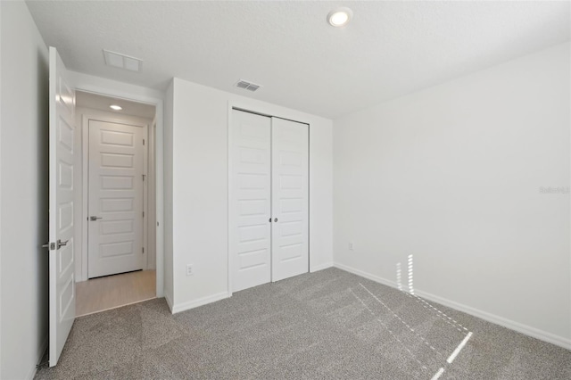 unfurnished bedroom with a closet and carpet floors