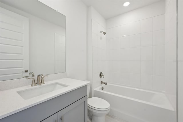 full bathroom featuring tiled shower / bath combo, toilet, and vanity