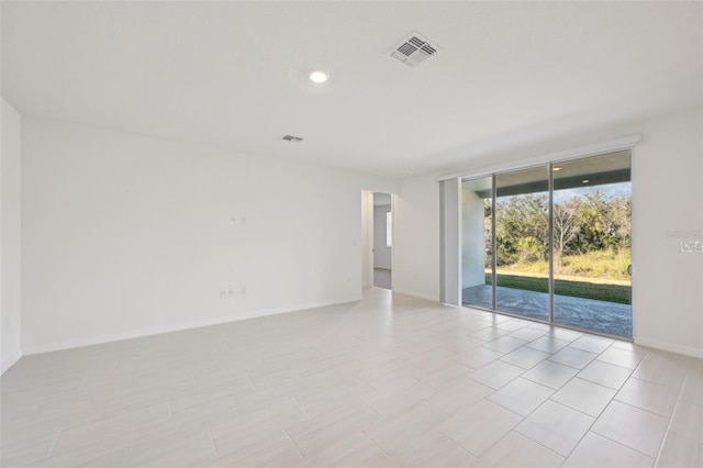 empty room featuring expansive windows and light tile patterned floors