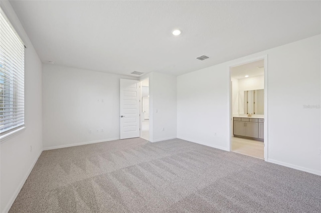 unfurnished room with a healthy amount of sunlight and light colored carpet