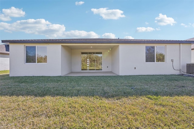 rear view of house with a patio area, a yard, and central AC