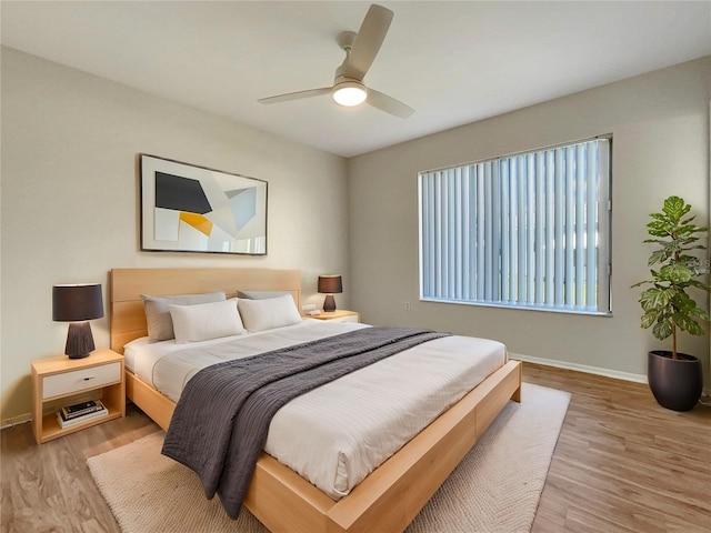 bedroom with baseboards, ceiling fan, and wood finished floors