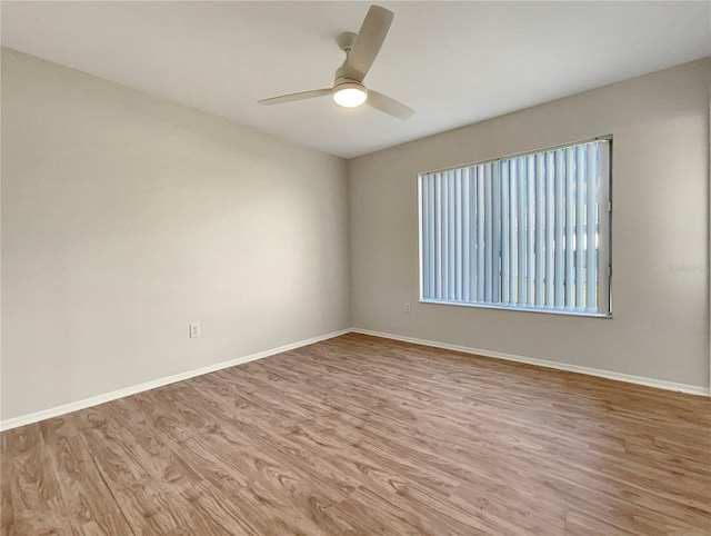 empty room with ceiling fan and light hardwood / wood-style flooring