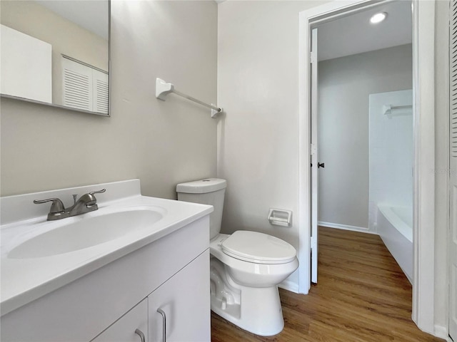 bathroom with vanity, toilet, and wood finished floors