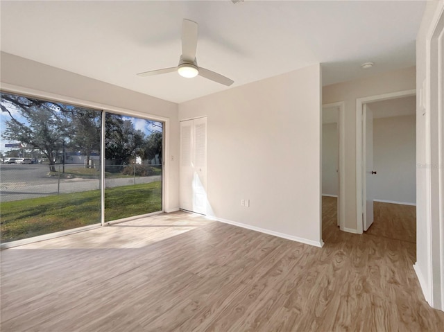 unfurnished room with baseboards, ceiling fan, and wood finished floors