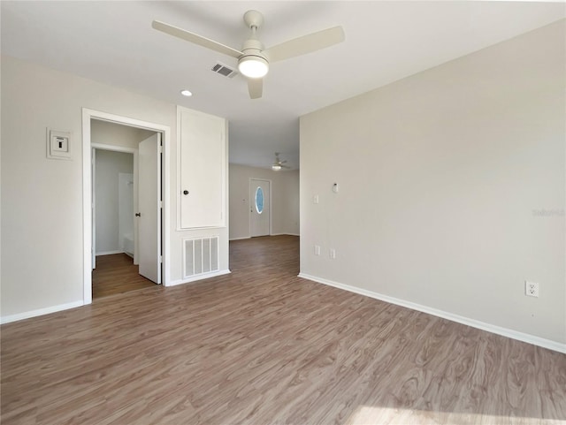 spare room featuring light wood-style floors, ceiling fan, and visible vents