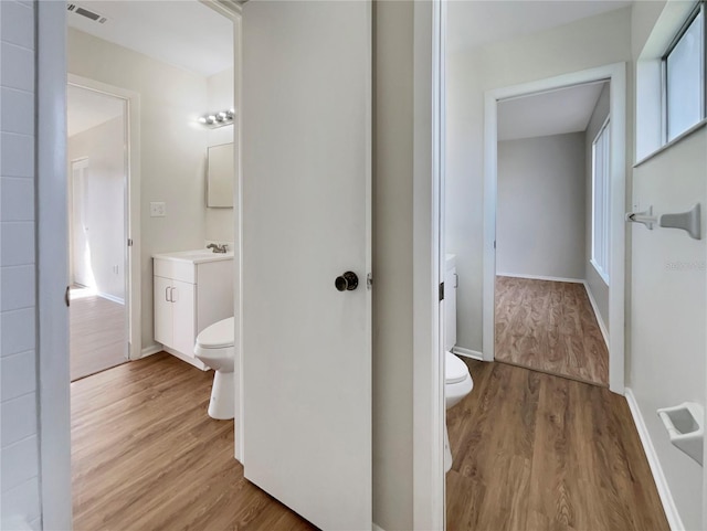 bathroom featuring visible vents, wood finished floors, toilet, and vanity