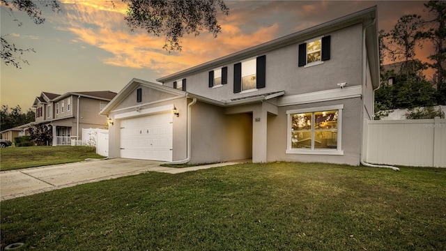 view of property featuring a garage and a lawn