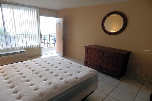 tiled bedroom with a wall mounted AC and access to exterior