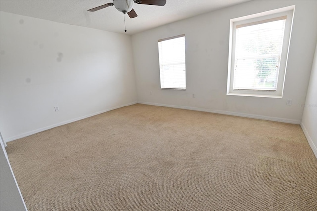 carpeted spare room featuring ceiling fan