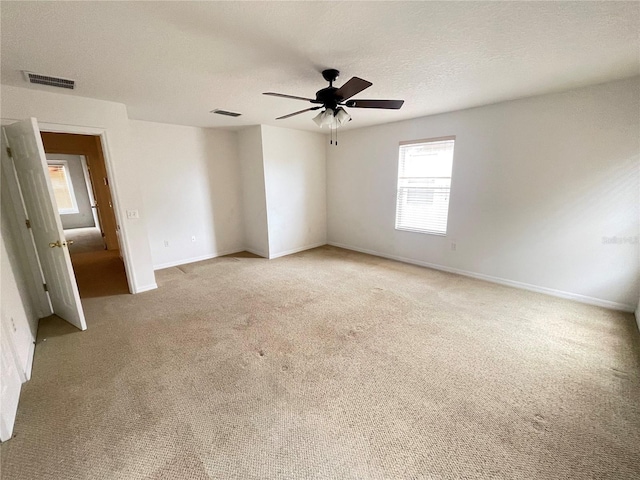 carpeted spare room with ceiling fan and a textured ceiling