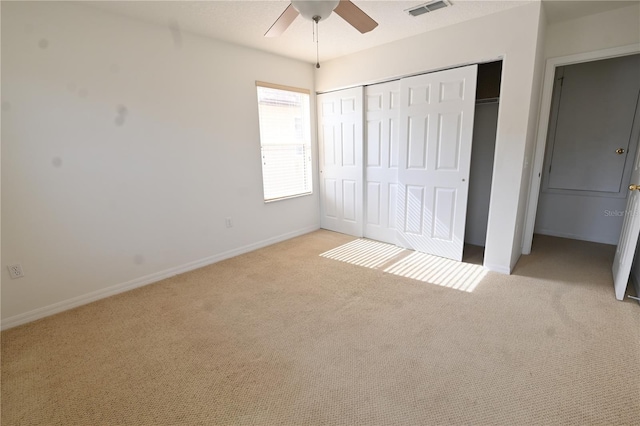 unfurnished bedroom with ceiling fan, a closet, and light colored carpet