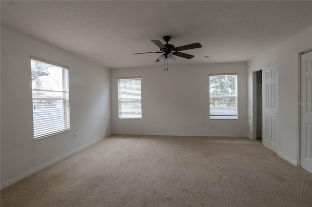 empty room with ceiling fan and light colored carpet