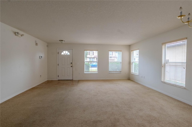 carpeted foyer with a textured ceiling