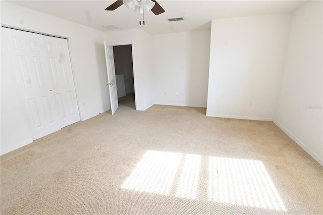 unfurnished bedroom featuring ceiling fan, a closet, and light carpet