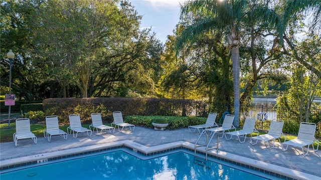 view of pool featuring a patio and a water view