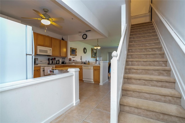 kitchen with ceiling fan, kitchen peninsula, decorative light fixtures, white appliances, and light tile patterned floors