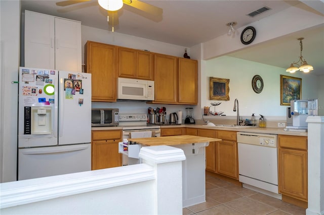 kitchen featuring white appliances, ceiling fan with notable chandelier, sink, hanging light fixtures, and light tile patterned flooring