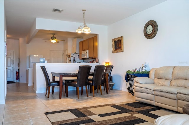 dining room with beam ceiling, light tile patterned floors, and ceiling fan with notable chandelier