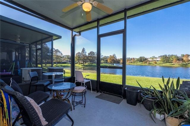 sunroom featuring ceiling fan and a water view