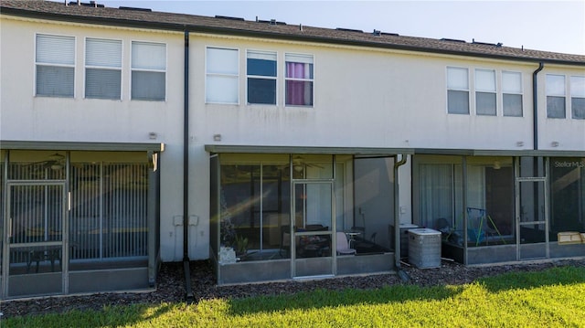 rear view of property with a sunroom and central AC