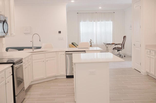 kitchen with white cabinets, sink, light wood-type flooring, an island with sink, and stainless steel appliances