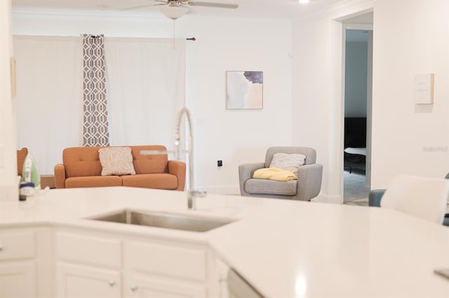 living room featuring crown molding, sink, and ceiling fan