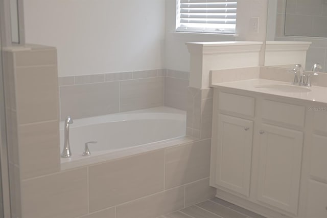 bathroom with vanity and tiled bath