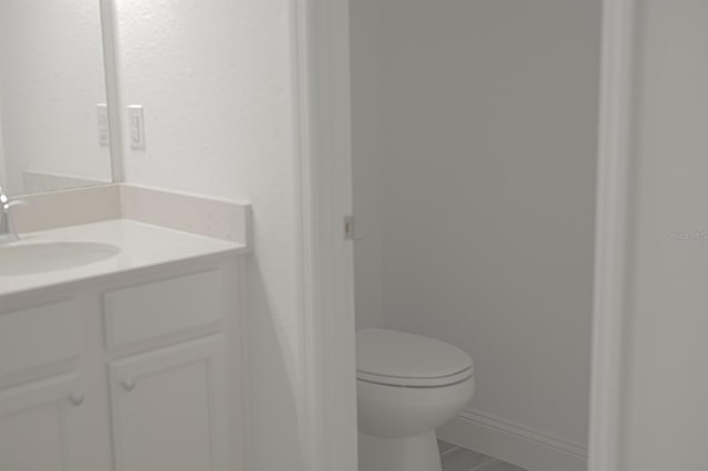 bathroom with tile patterned flooring, vanity, and toilet