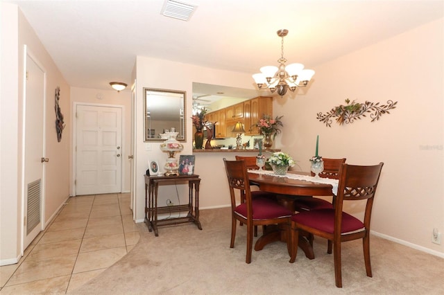 dining space with a chandelier, baseboards, and light colored carpet
