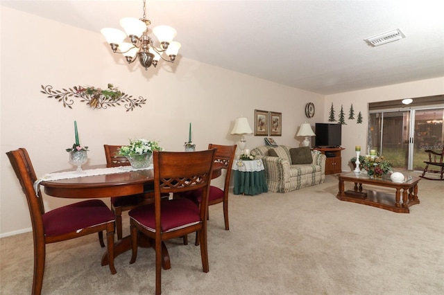 carpeted dining room with a chandelier