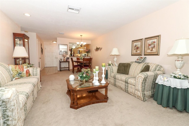 carpeted living room featuring a notable chandelier