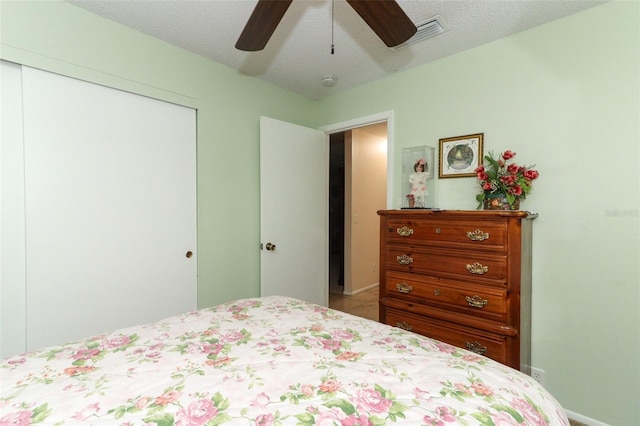 bedroom featuring a closet, ceiling fan, and a textured ceiling