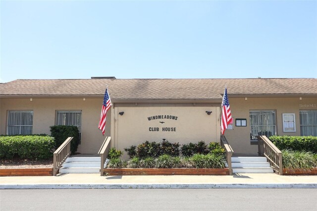 view of front of house featuring stucco siding and a shingled roof