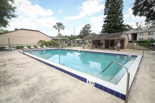 community pool featuring fence and a patio area