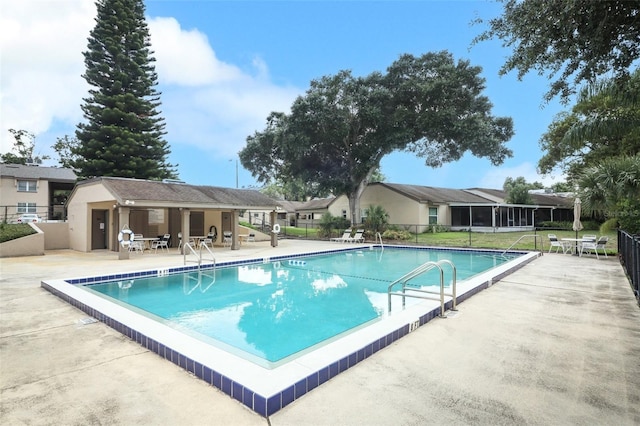 community pool with fence and a patio