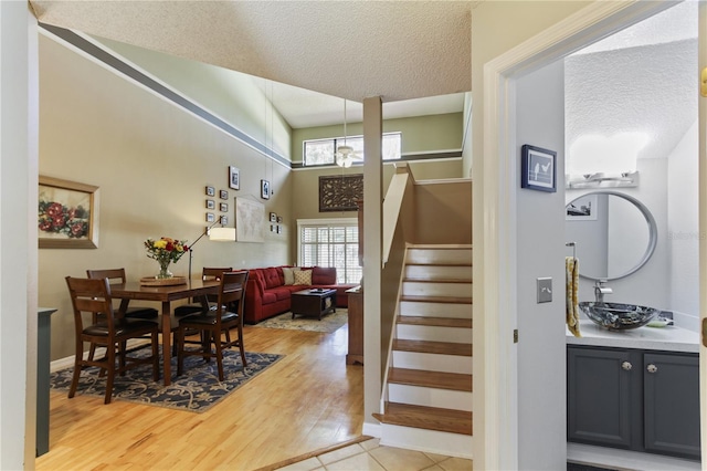 interior space featuring a textured ceiling, sink, hardwood / wood-style floors, and a high ceiling